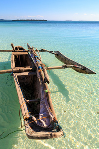 传统的渔夫船躺在清澈的水中海滩附近