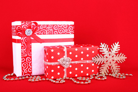美丽明亮的礼品和圣诞装饰红色背景上