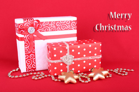 美丽明亮的礼品和圣诞装饰红色背景上