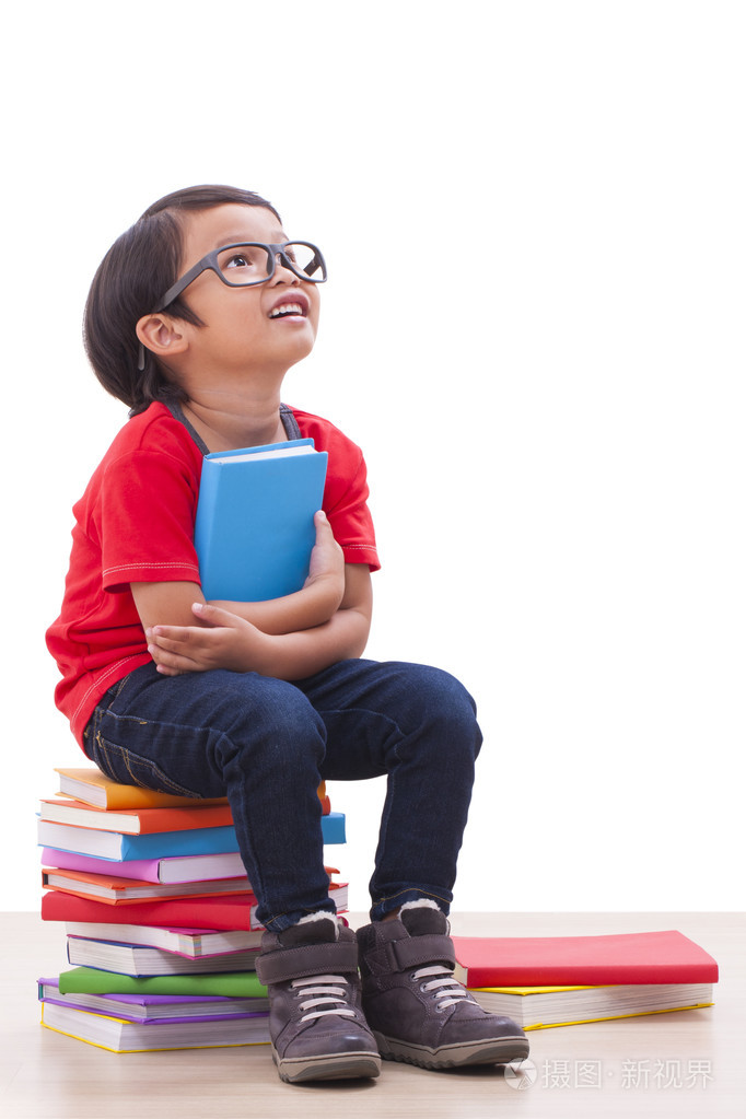 可爱的小男孩坐着,拿着书