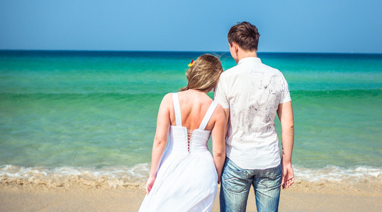 恩爱夫妻打击海的热带海滩上图片
