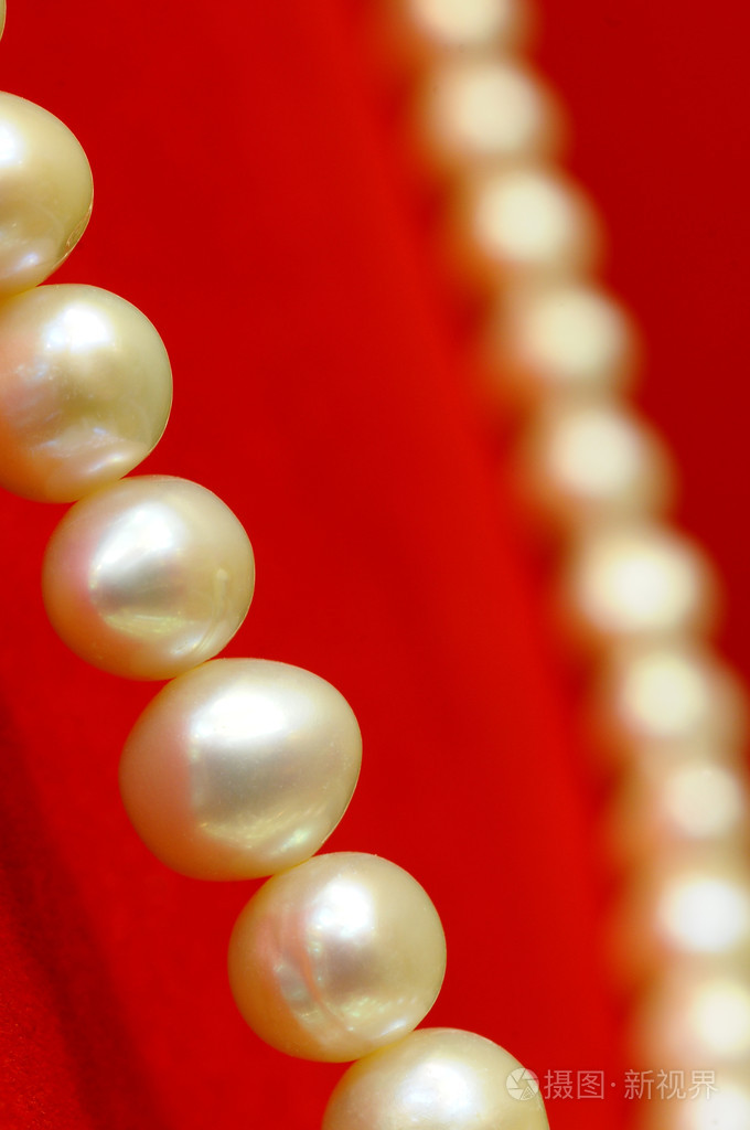 在豪华红色背景上的珍珠项链