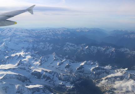 白雪覆盖的山峰与高空飞机图片