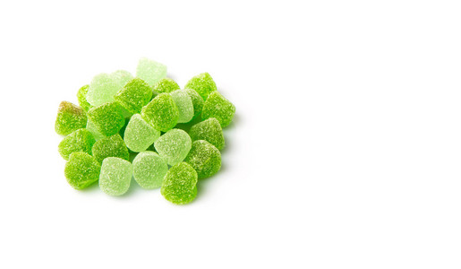在白色上分离出的甜绿色果冻糖果照片