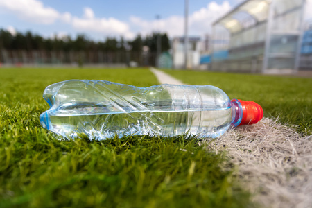塑料瓶水躺在草坪足球场照片