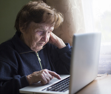 老女人在笔记本电脑上工作
