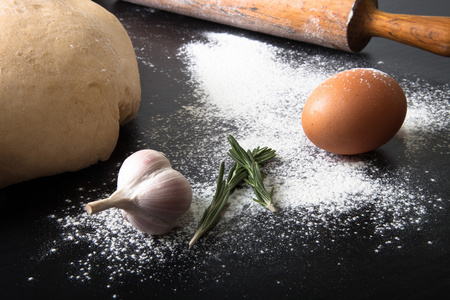 面粉 擀面杖 鸡蛋 迷迭香 大蒜和馅饼的面团