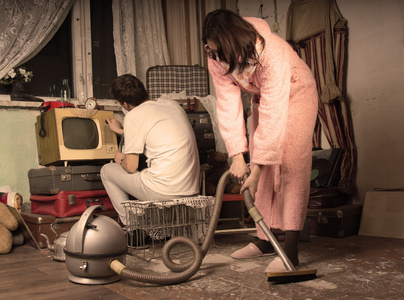 复古的家庭主妇清洗凌乱的客厅里照片