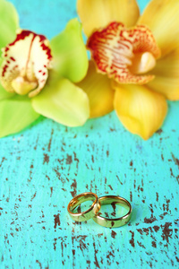 结婚戒指和兰花花，特写时，颜色木制背景