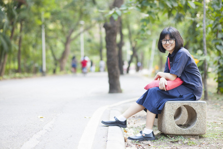 女孩戴着眼镜坐在走廊的长椅上