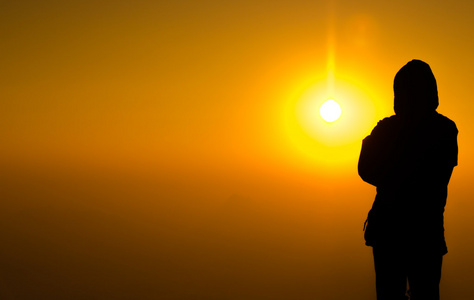 剪影男子站在七彩的阳光明亮的背景上