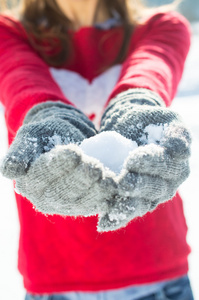 女孩玩雪中的红毛衣和手套