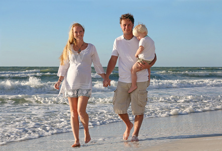 幸福的家庭，三人走上海滩沿着海洋