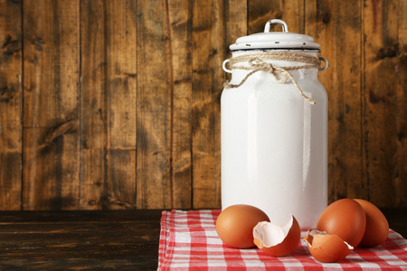 牛奶可以用鸡蛋和蛋壳仿古木制背景上的餐巾