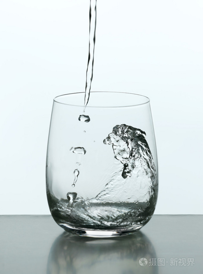 从玻璃上白色孤立的瓶子里倒水