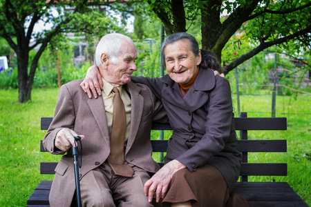 可爱的 80 加岁已婚夫妇摆姿势让你在他们的花园中的一幅肖像。永远爱概念