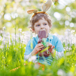 小孩头戴复活节兔子耳朵和在 s 吃巧克力