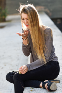 快乐的金发女孩微笑在城市背景