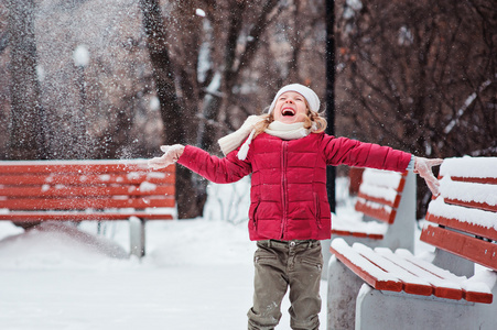 快乐的孩子女孩抛雪和欢笑中白雪皑皑的冬季公园