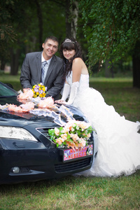新郎与新娘在婚礼车附近