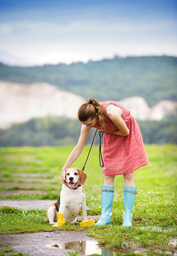 长筒靴的女人走她比格犬