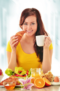 吃早饭的年轻女人。均衡的饮食