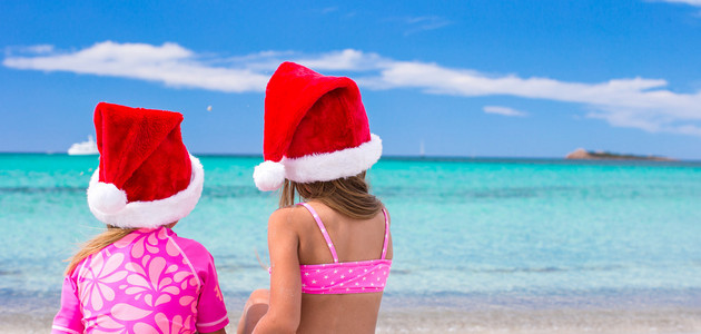 圣诞老人的帽子在海滩度假的可爱女孩