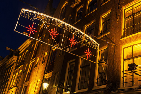 晚上在阿姆斯特丹，荷兰，老城街道照明与黑暗的小巷