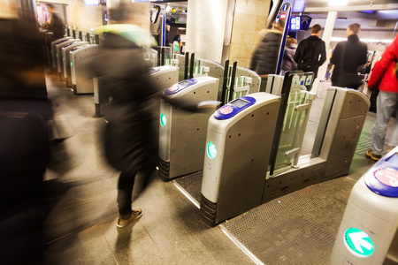 地铁站点人在运动模糊点的一个地铁站的旋转门照片