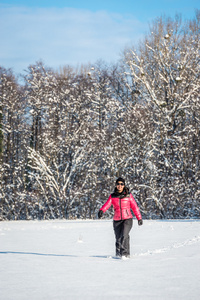 年轻女子走在白雪覆盖的领域