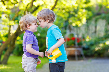 两个小的同级男孩拥抱和在户外玩得开心