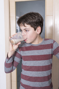 年轻的男孩喝一杯牛奶