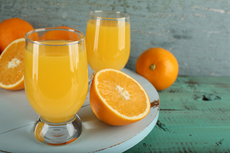 杯橙汁与切片上颜色木制背景