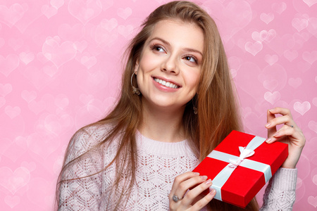 甜美的金发女人,拿着一份礼物盒.heartshaped 散景背景快乐照片