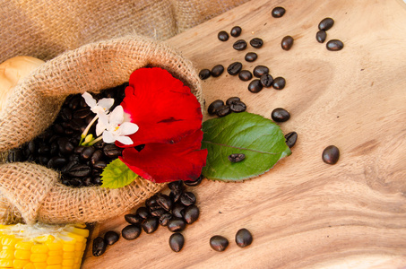 咖啡豆在麻袋里花布里恩与玉米的木制背景.decoration