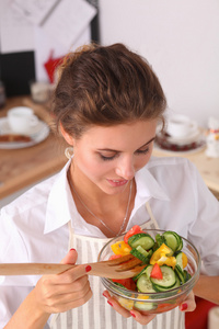 年轻女子在现代的厨房里吃新鲜的沙拉