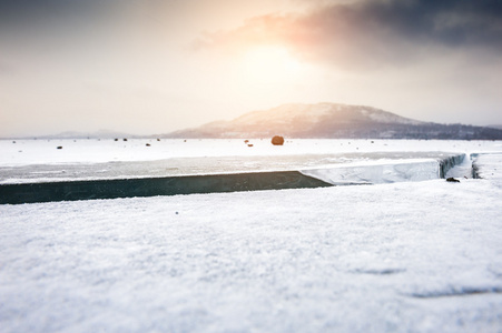 在日落时雪结冰的湖面