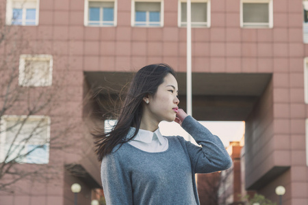 在城市的街道构成的年轻漂亮的中国女孩