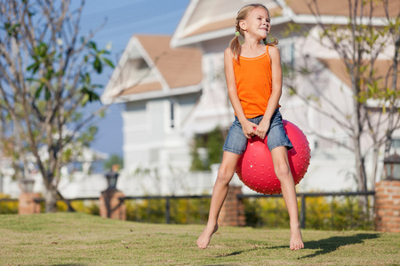 快乐的女孩玩充气球在草坪上图片