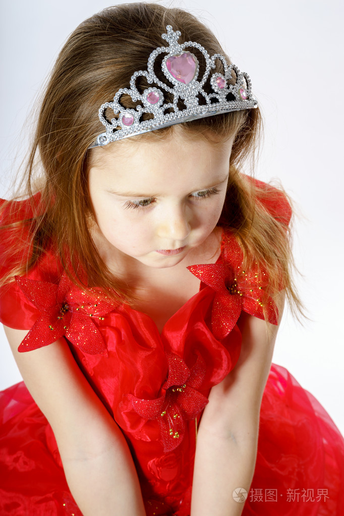 可爱的小公主穿红色的衣服与冠上她头的位置