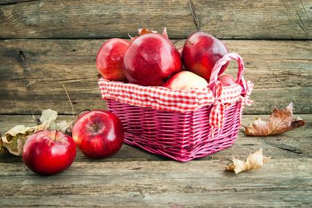 在木制背景上篮子里的红苹果