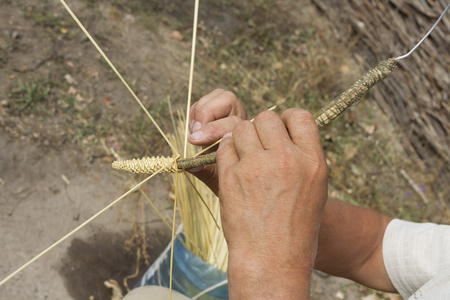 从稻草玩具编织的人的手图片