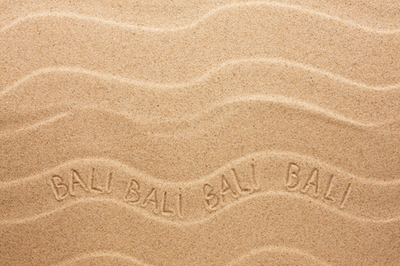 巴厘岛题字在波浪的沙滩上图片