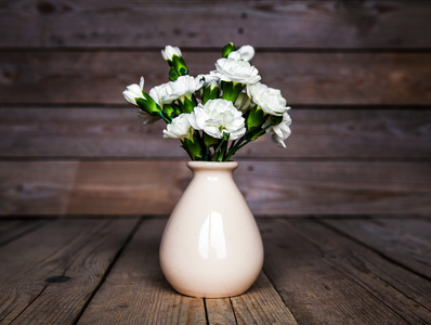 精致束康乃馨古董花瓶及木制背景上心。情人节那天
