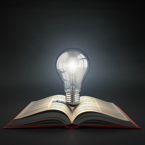发光的灯泡上打开的书。想法或创意概念。教育署