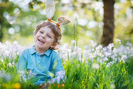 可爱快乐的小男孩，穿着绿色的春天复活节兔子耳朵