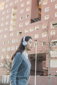 年轻漂亮的中国女孩，戴着耳机