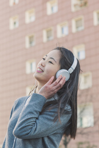 年轻漂亮的中国女孩，戴着耳机