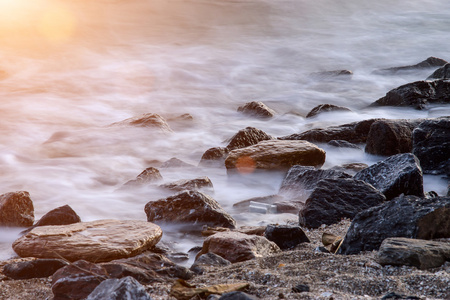 长时间曝光的朦胧大海和海滩上的岩石