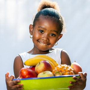 可爱的非洲女孩抱着水果碗